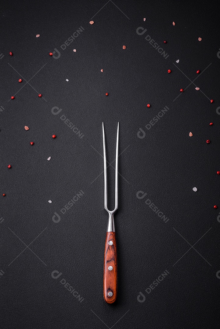 Garfo sobre mesa de concreto preto com pimenta rosa e sal do Himalaia. Pode ser usado como plano de fundo