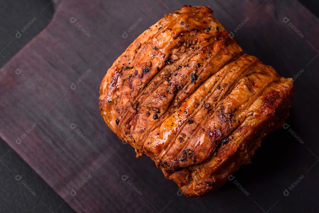 Deliciosa carne ou presunto fresco defumado com especiarias e ervas sobre um fundo escuro de concreto
