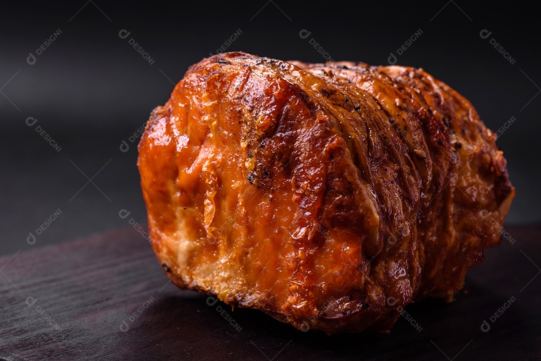 Deliciosa carne ou presunto fresco defumado com especiarias e ervas sobre um fundo escuro de concreto