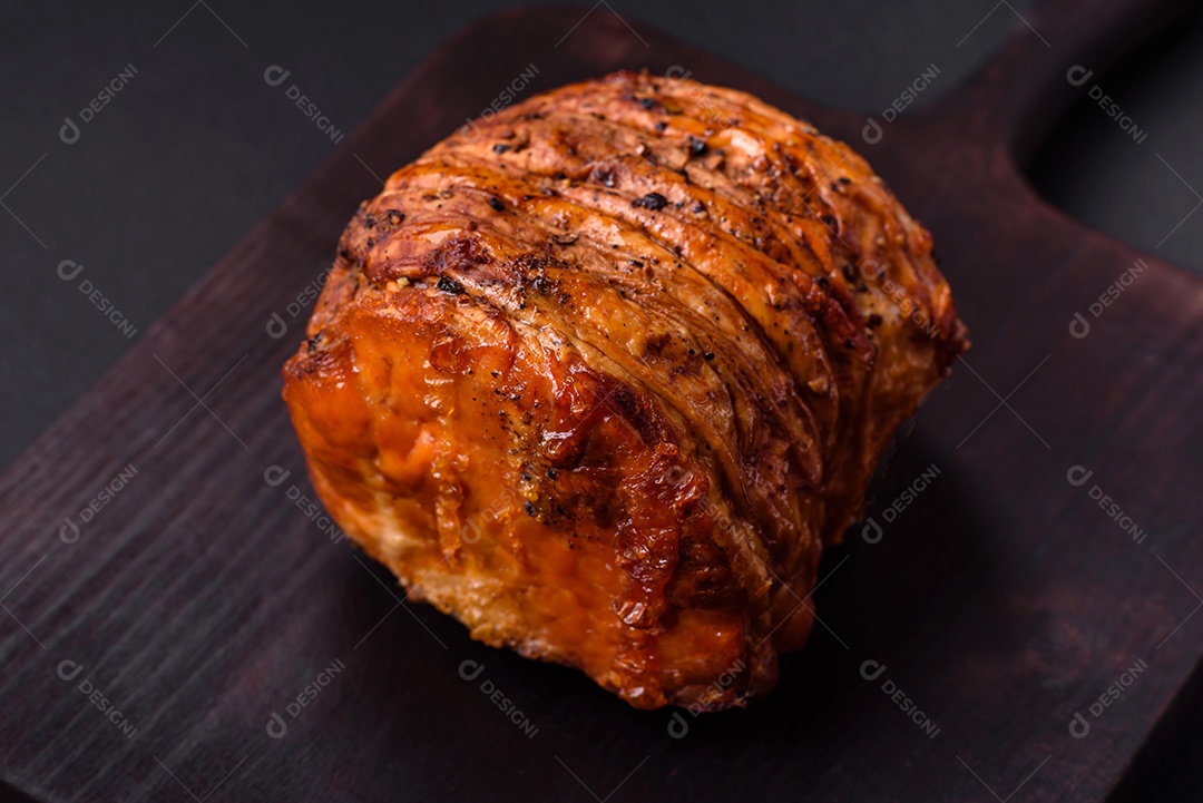 Deliciosa carne ou presunto fresco defumado com especiarias e ervas sobre um fundo escuro de concreto