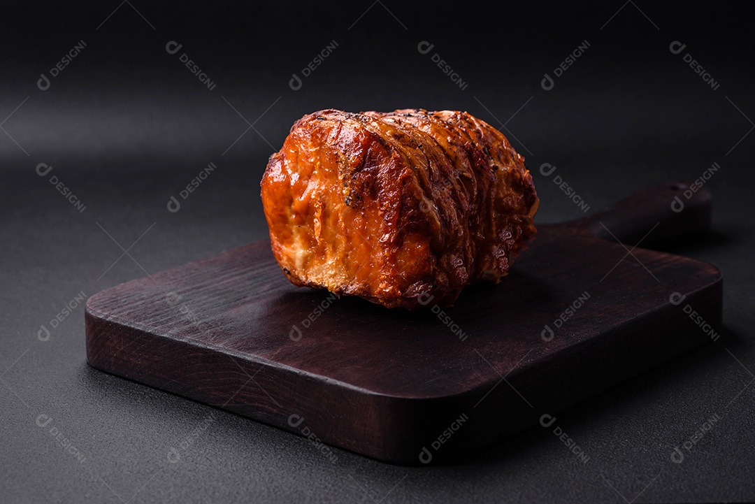 Deliciosa carne ou presunto fresco defumado com especiarias e ervas sobre um fundo escuro de concreto