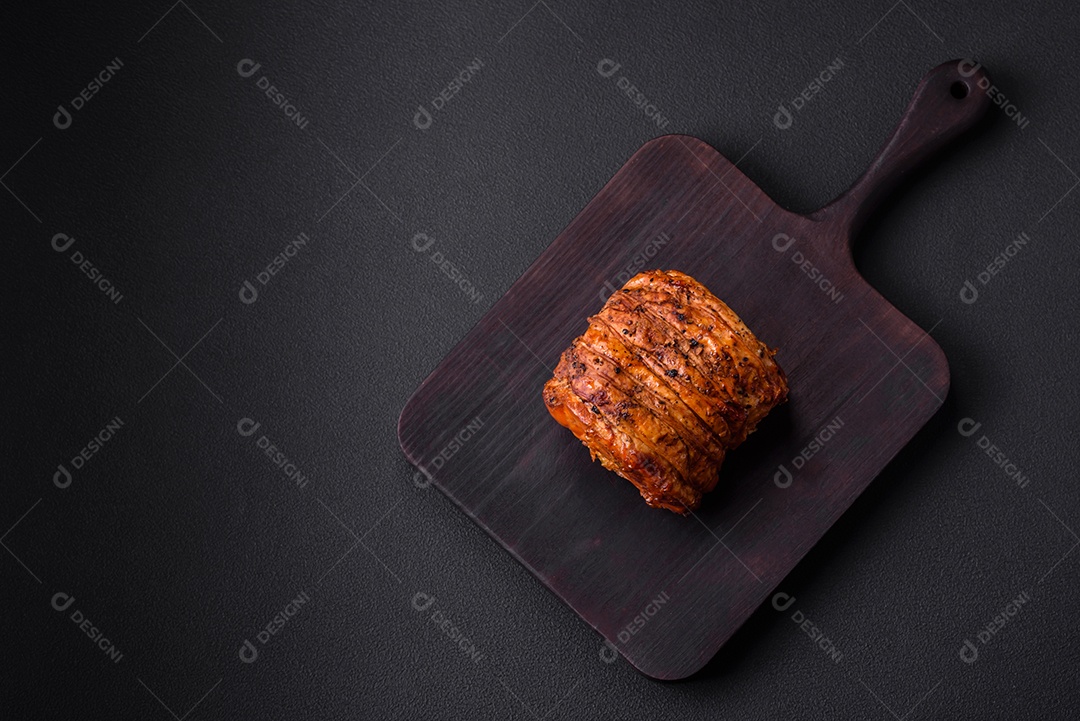 Deliciosa carne ou presunto fresco defumado com especiarias e ervas sobre um fundo escuro de concreto