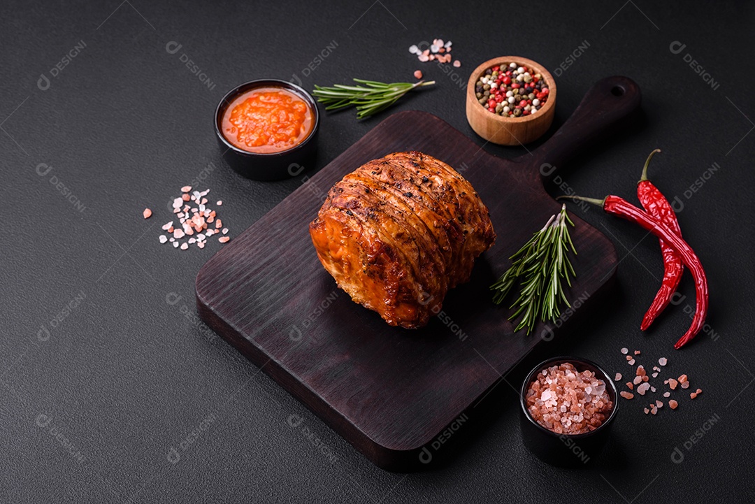 Deliciosa carne ou presunto fresco defumado com especiarias e ervas sobre um fundo escuro de concreto