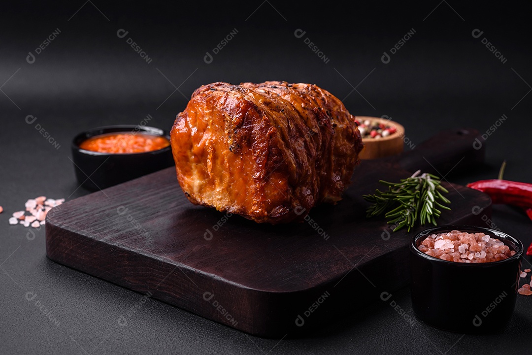 Deliciosa carne ou presunto fresco defumado com especiarias e ervas sobre um fundo escuro de concreto