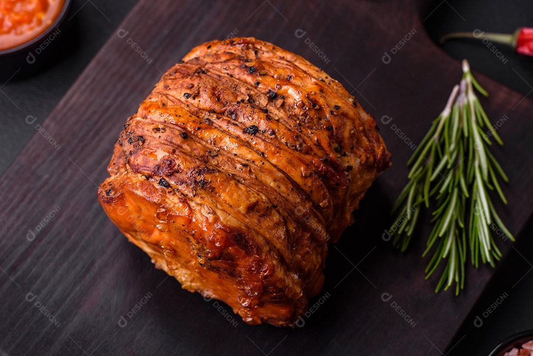 Deliciosa carne ou presunto fresco defumado com especiarias e ervas sobre um fundo escuro de concreto