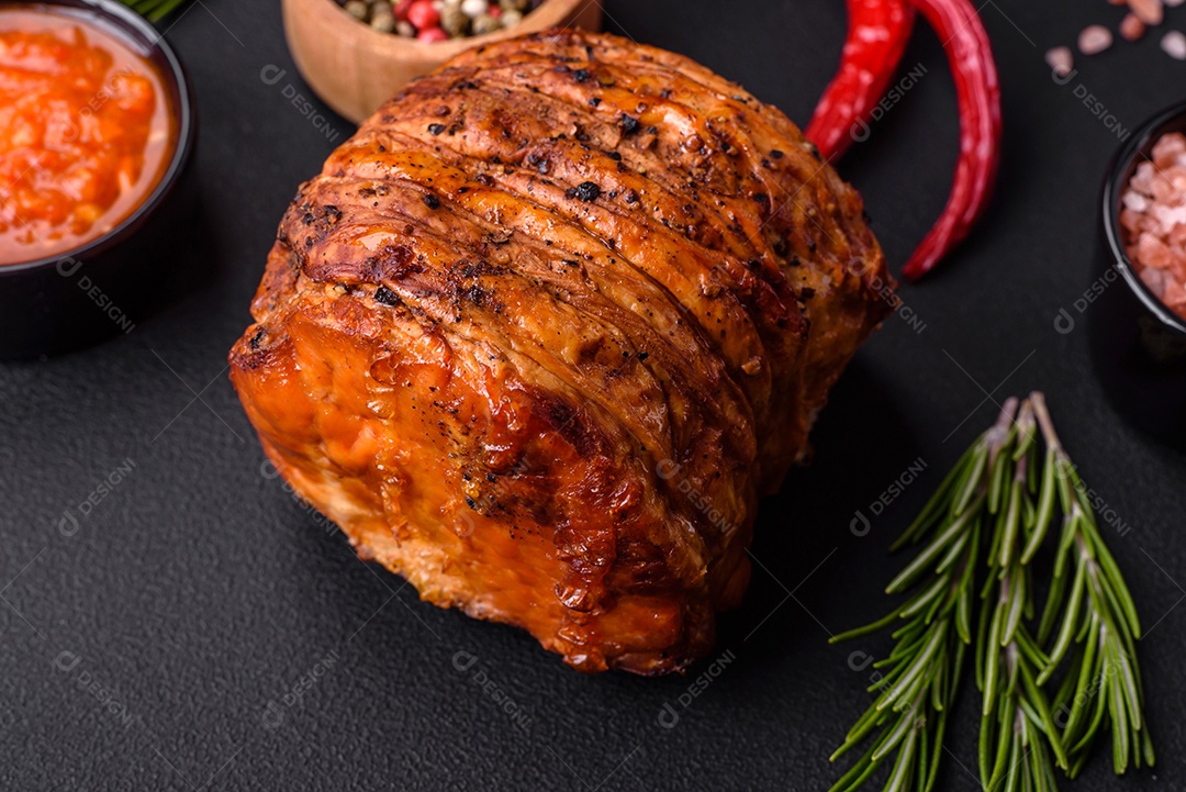 Deliciosa carne ou presunto fresco defumado com especiarias e ervas sobre um fundo escuro de concreto