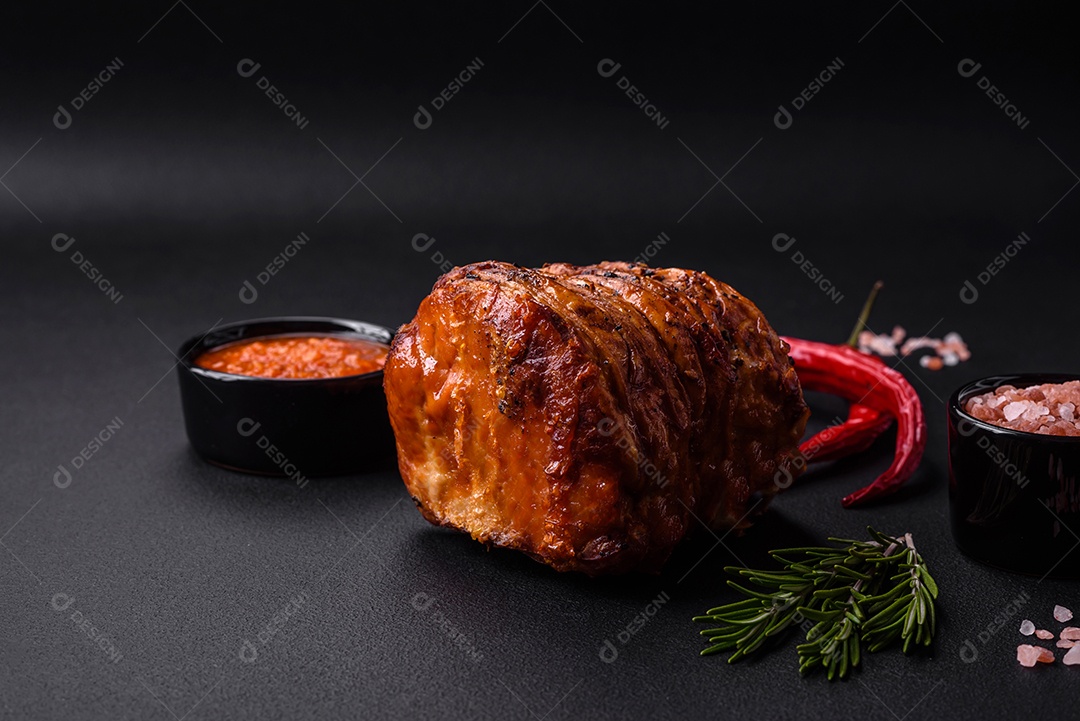 Deliciosa carne ou presunto fresco defumado com especiarias e ervas sobre um fundo escuro de concreto