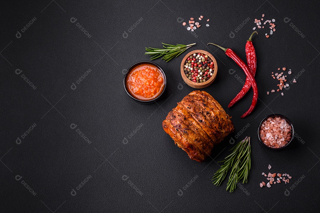 Deliciosa carne ou presunto fresco defumado com especiarias e ervas sobre um fundo escuro de concreto