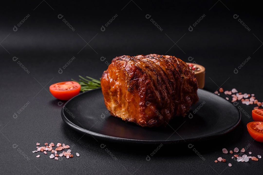 Deliciosa carne ou presunto fresco defumado com especiarias e ervas sobre um fundo escuro de concreto