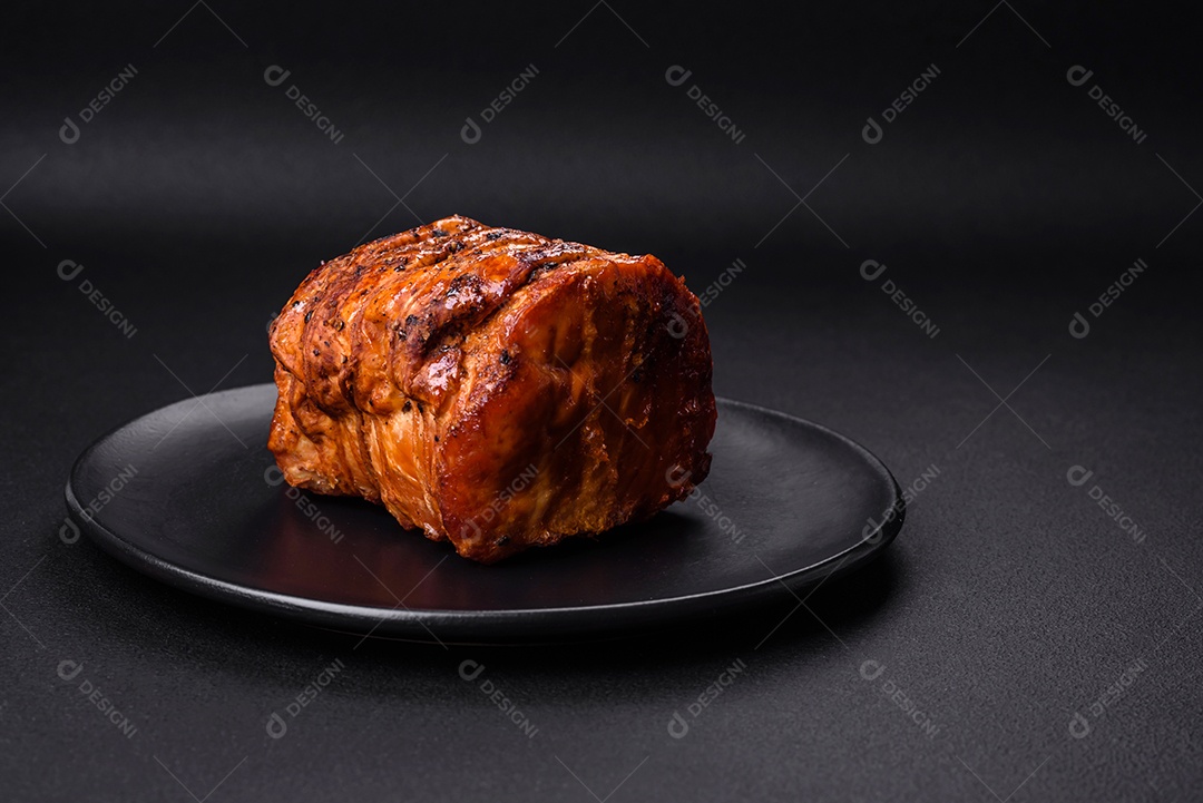 Deliciosa carne ou presunto fresco defumado com especiarias e ervas sobre um fundo escuro de concreto