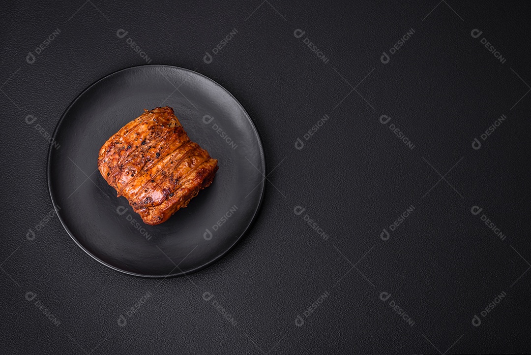 Deliciosa carne ou presunto fresco defumado com especiarias e ervas sobre um fundo escuro de concreto