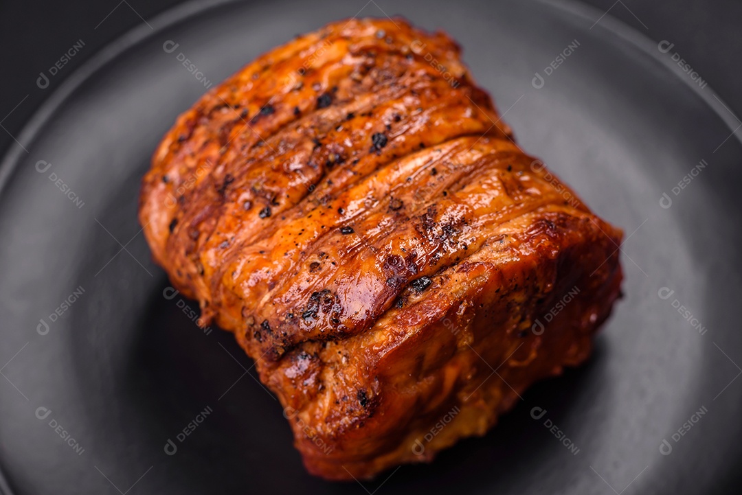 Deliciosa carne ou presunto fresco defumado com especiarias e ervas sobre um fundo escuro de concreto