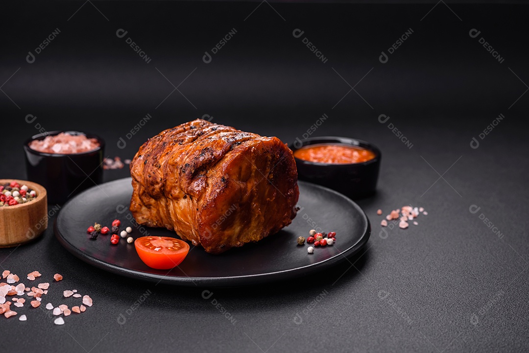 Deliciosa carne ou presunto fresco defumado com especiarias e ervas sobre um fundo escuro de concreto