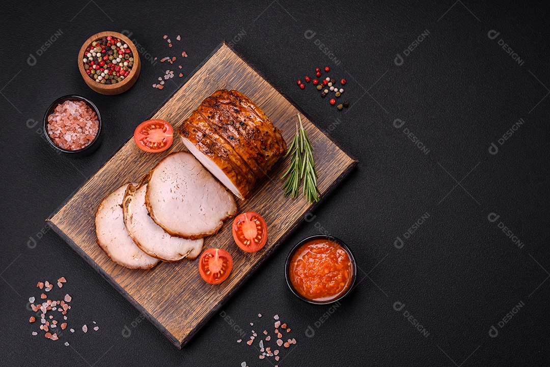 Deliciosa carne ou presunto fresco defumado com especiarias e ervas sobre um fundo escuro de concreto