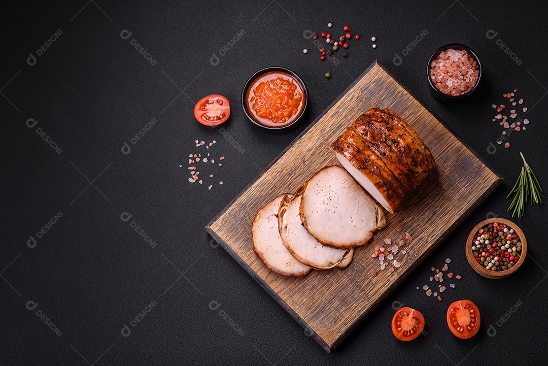 Deliciosa carne ou presunto fresco defumado com especiarias e ervas sobre um fundo escuro de concreto