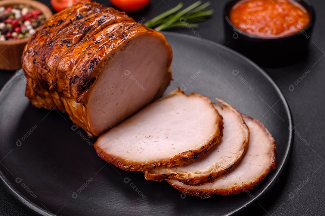 Deliciosa carne ou presunto fresco defumado com especiarias e ervas sobre um fundo escuro de concreto