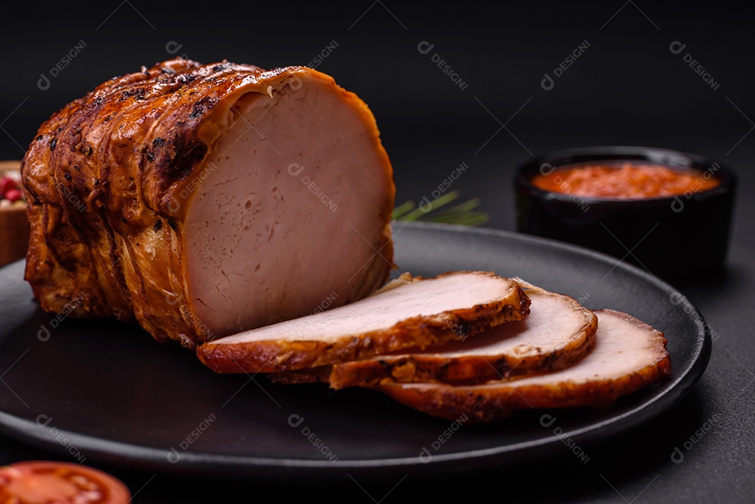 Deliciosa carne ou presunto fresco defumado com especiarias e ervas sobre um fundo escuro de concreto