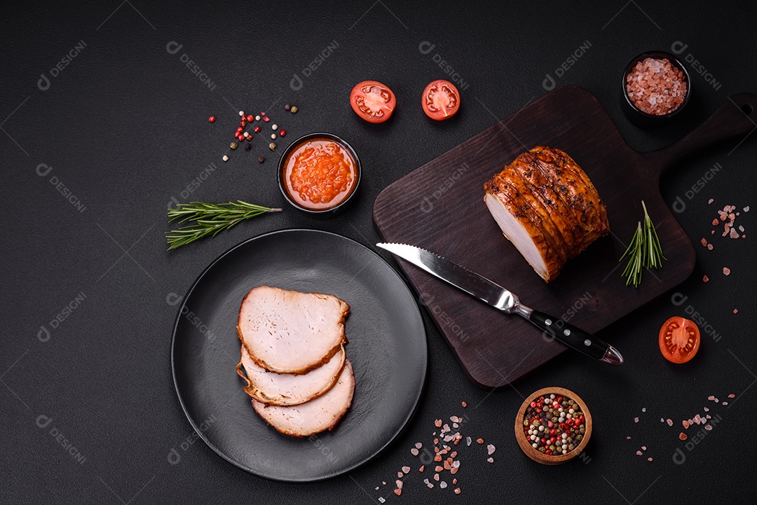 Deliciosa carne ou presunto fresco defumado com especiarias e ervas sobre um fundo escuro de concreto