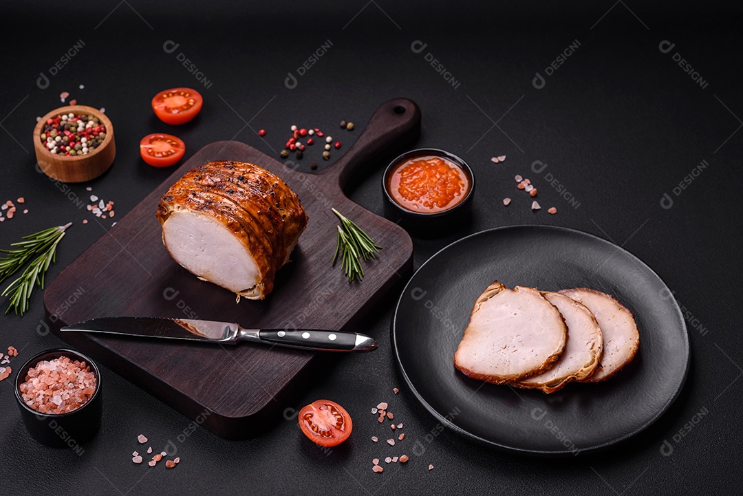 Deliciosa carne ou presunto fresco defumado com especiarias e ervas sobre um fundo escuro de concreto