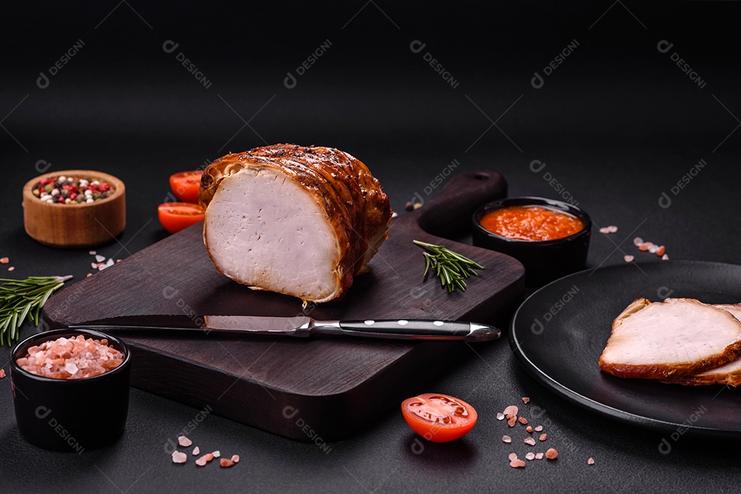 Deliciosa carne ou presunto fresco defumado com especiarias e ervas sobre um fundo escuro de concreto