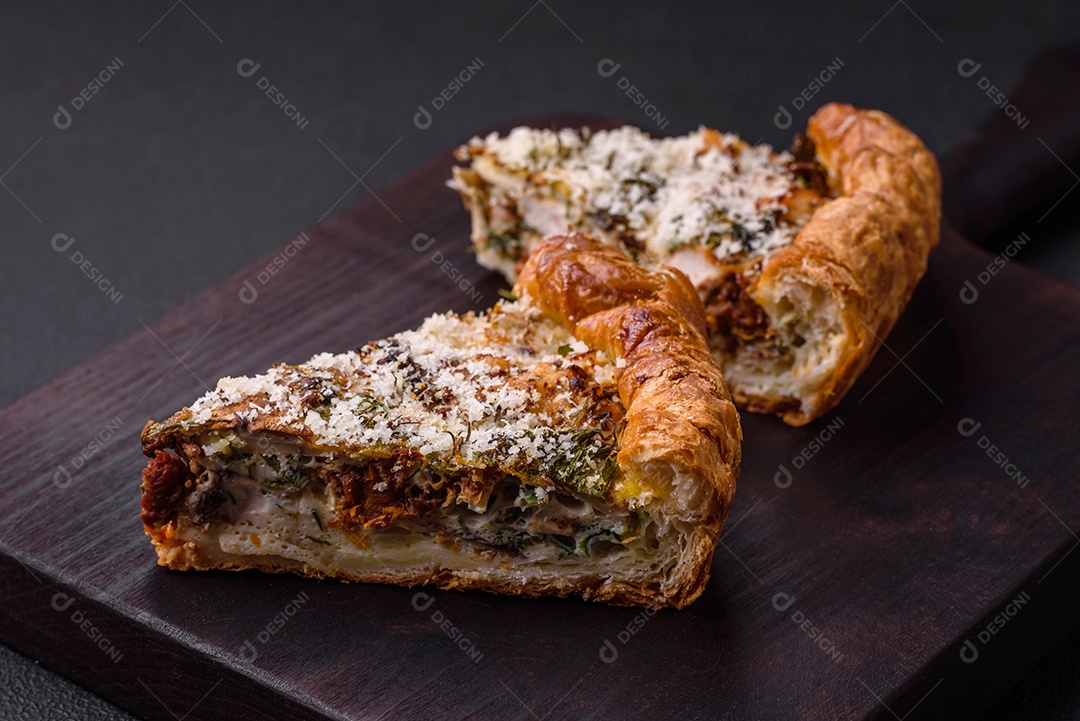 Deliciosa quiche com frango, queijo, ervas, especiarias e ervas sobre um fundo escuro de concreto