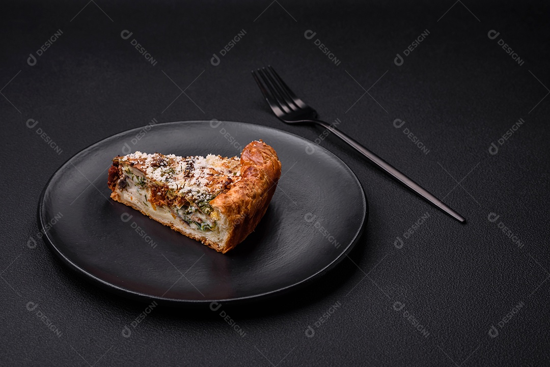 Deliciosa quiche com frango, queijo, ervas, especiarias e ervas sobre um fundo escuro de concreto