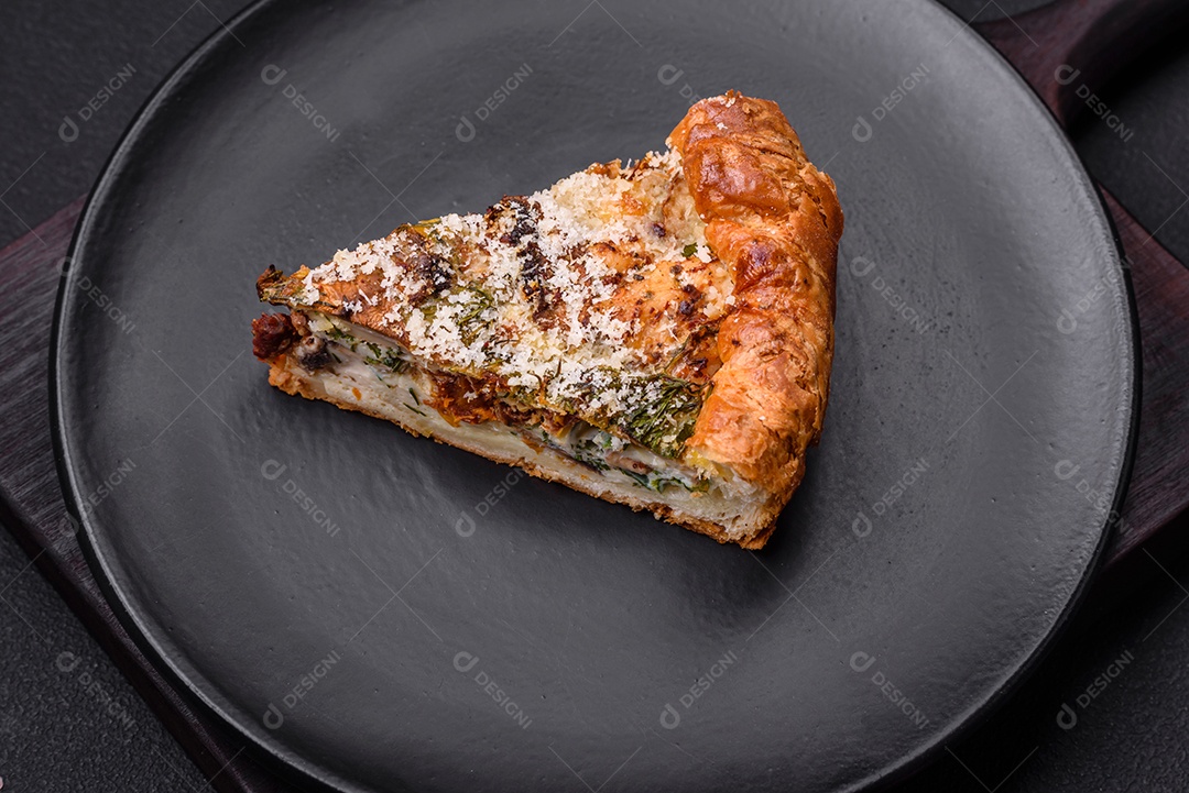 Deliciosa quiche com frango, queijo, ervas, especiarias e ervas sobre um fundo escuro de concreto