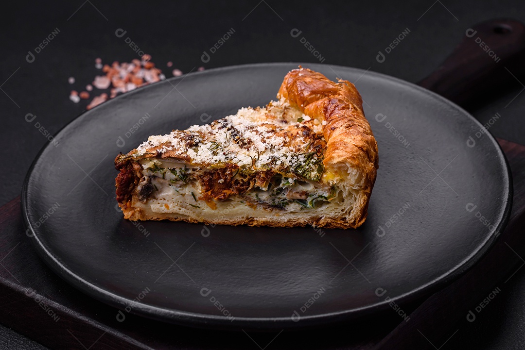 Deliciosa quiche com frango, queijo, ervas, especiarias e ervas sobre um fundo escuro de concreto