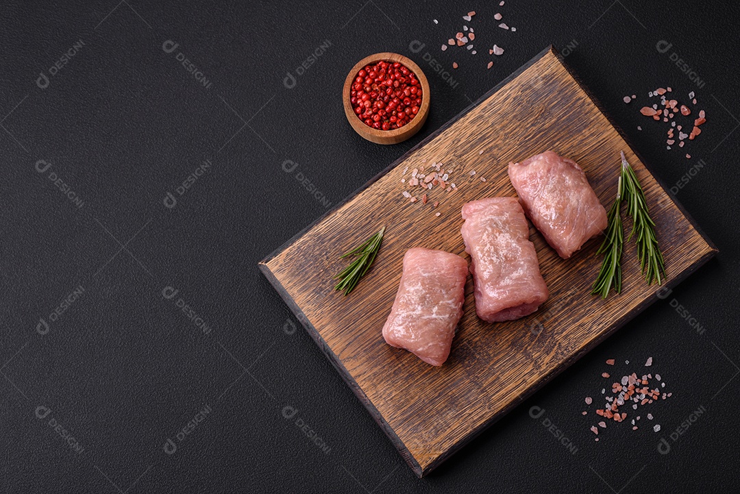 Delicioso rolo de carne de frango ou porco com cogumelos, queijo, especiarias e ervas sobre um fundo escuro de concreto