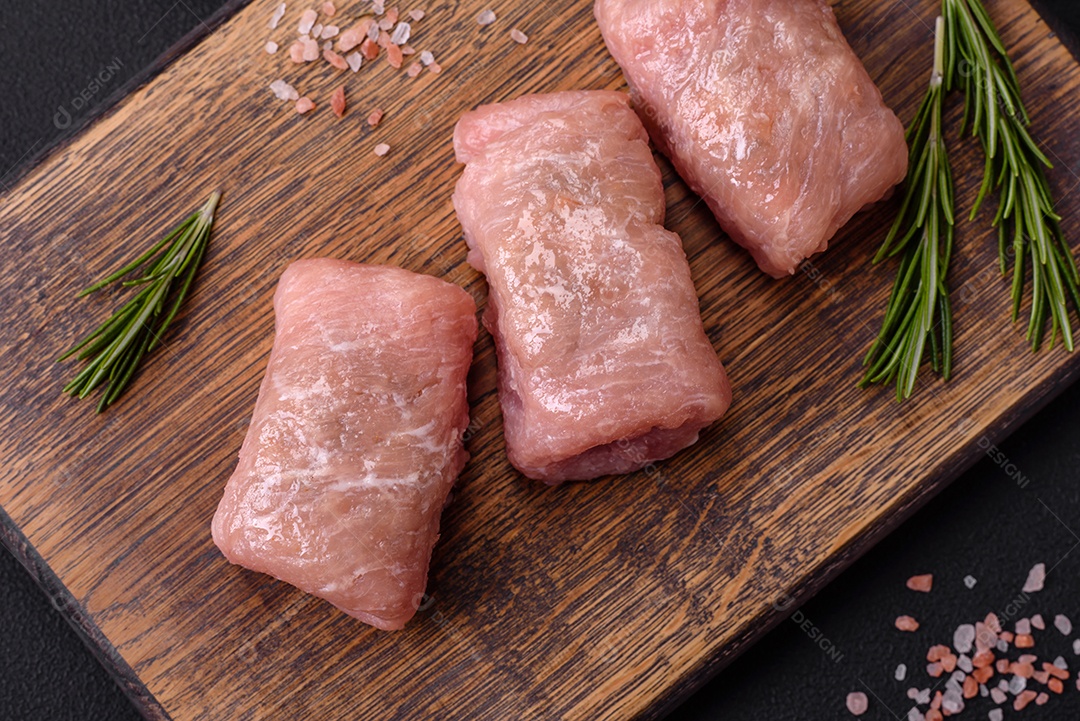 Delicioso rolo de carne de frango ou porco com cogumelos, queijo, especiarias e ervas sobre um fundo escuro de concreto