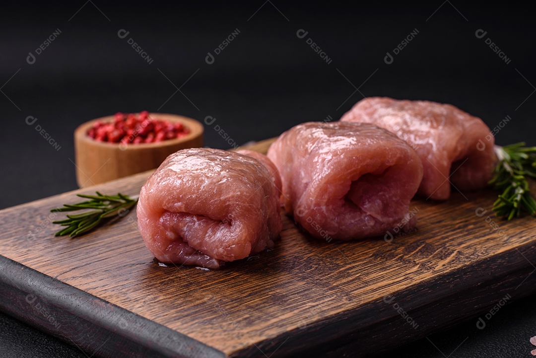 Delicioso rolo de carne de frango ou porco com cogumelos, queijo, especiarias e ervas sobre um fundo escuro de concreto