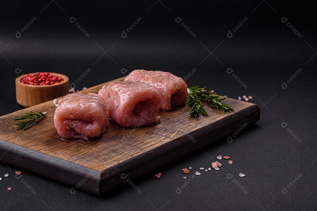 Delicioso rolo de carne de frango ou porco com cogumelos, queijo, especiarias e ervas sobre um fundo escuro de concreto
