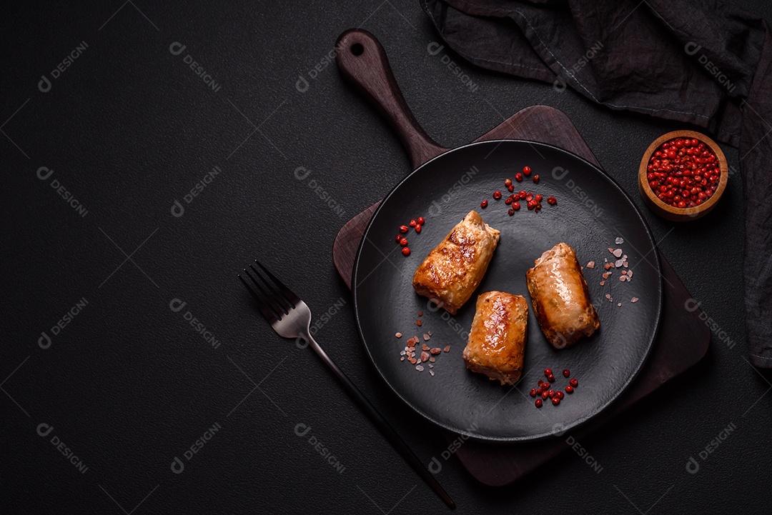 Delicioso rolo de carne de frango ou porco com cogumelos, queijo, especiarias e ervas sobre um fundo escuro de concreto