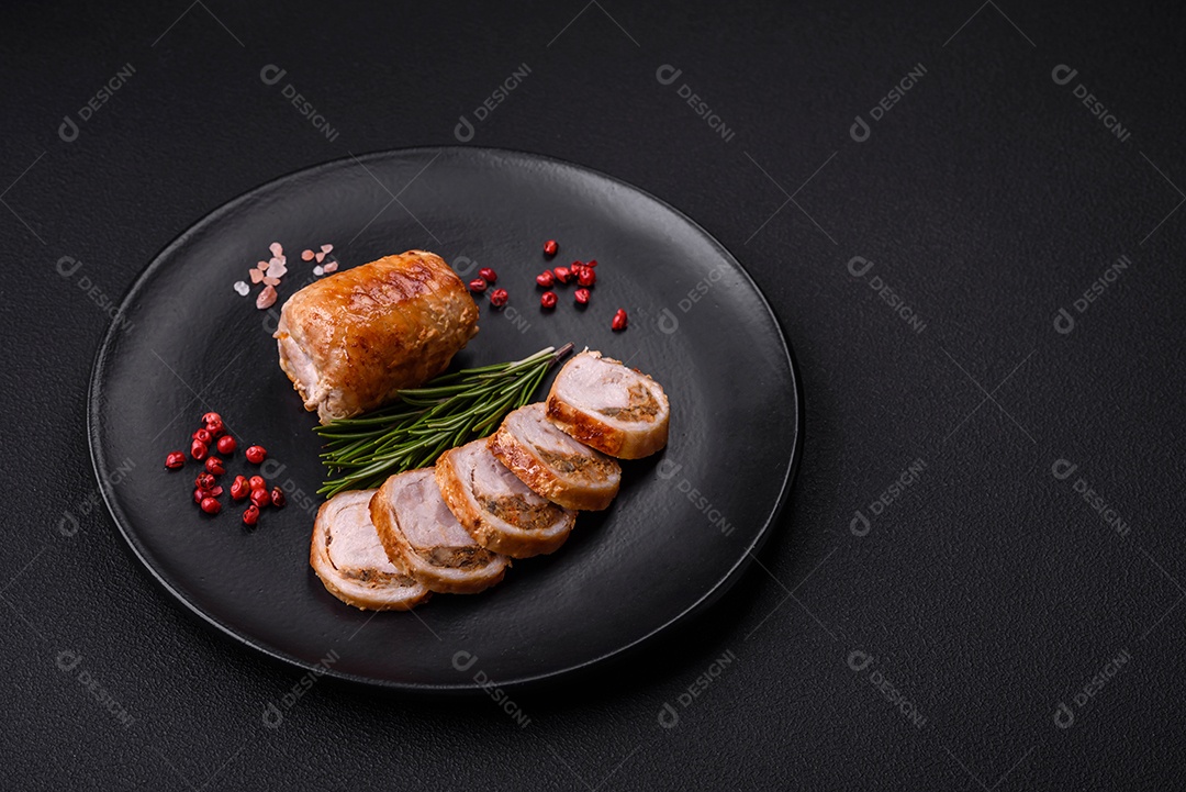 Delicioso rolo de carne de frango ou porco com cogumelos, queijo, especiarias e ervas sobre um fundo escuro de concreto