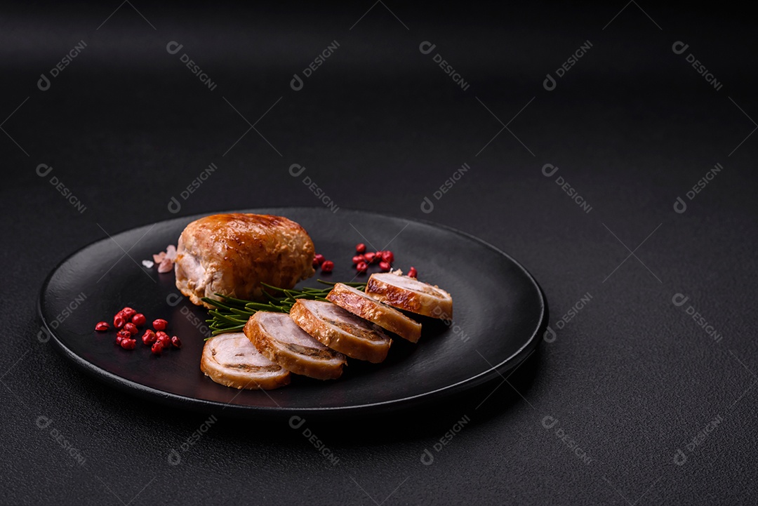 Delicioso rolo de carne de frango ou porco com cogumelos, queijo, especiarias e ervas sobre um fundo escuro de concreto