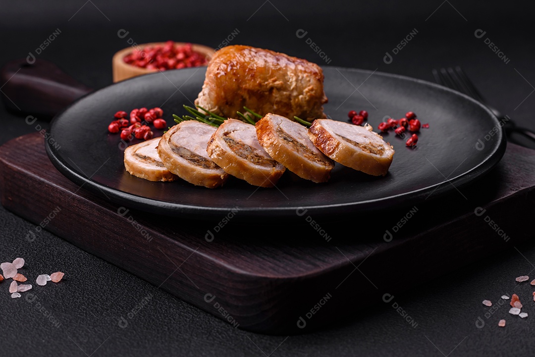 Delicioso rolo de carne de frango ou porco com cogumelos, queijo, especiarias e ervas sobre um fundo escuro de concreto