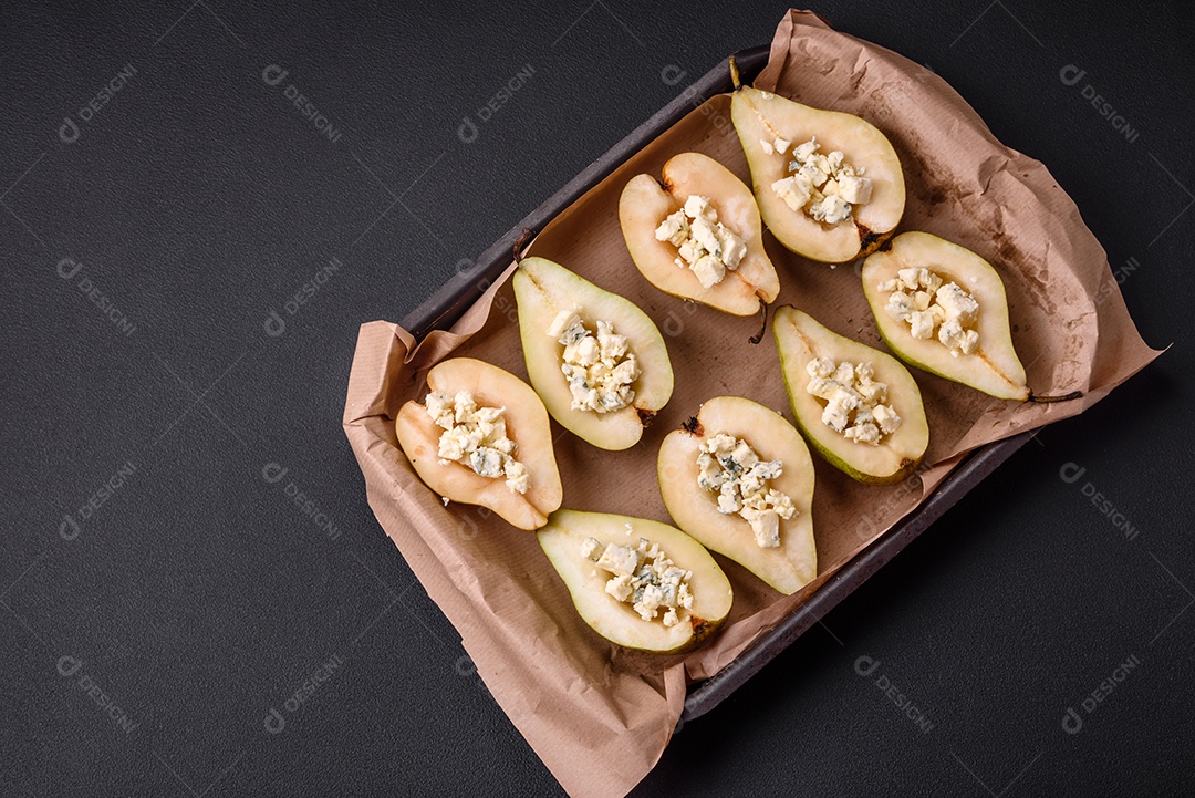 Deliciosa pêra assada com queijo dorblu, nozes e mel sobre um fundo de concreto texturizado. Prato vegetariano