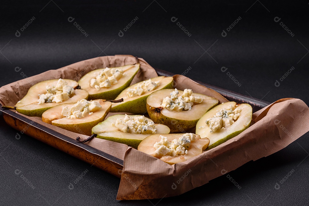 Deliciosa pêra assada com queijo dorblu, nozes e mel sobre um fundo de concreto texturizado. Prato vegetariano
