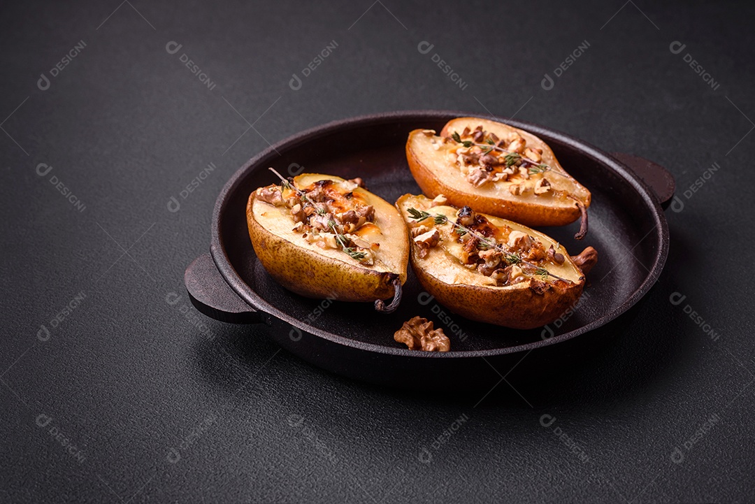 Deliciosa pêra assada com queijo dorblu, nozes e mel sobre um fundo de concreto texturizado. Prato vegetariano