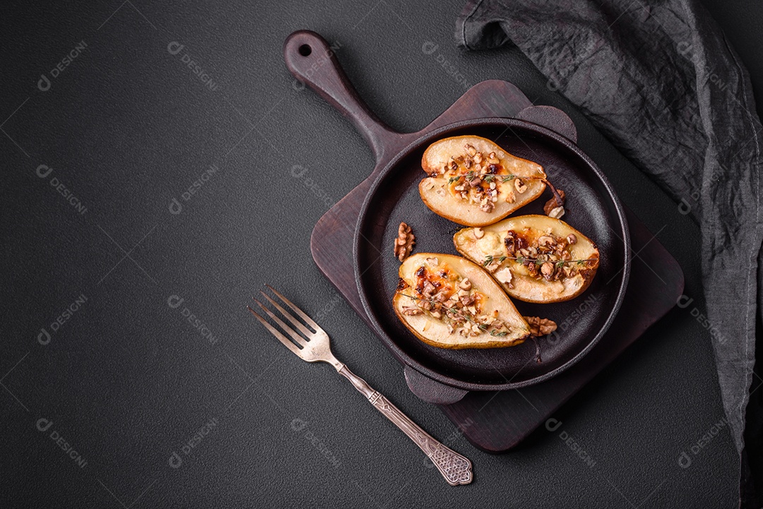 Deliciosa pêra assada com queijo dorblu, nozes e mel sobre um fundo de concreto texturizado. Prato vegetariano