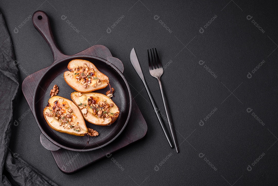 Deliciosa pêra assada com queijo dorblu, nozes e mel sobre um fundo de concreto texturizado. Prato vegetariano