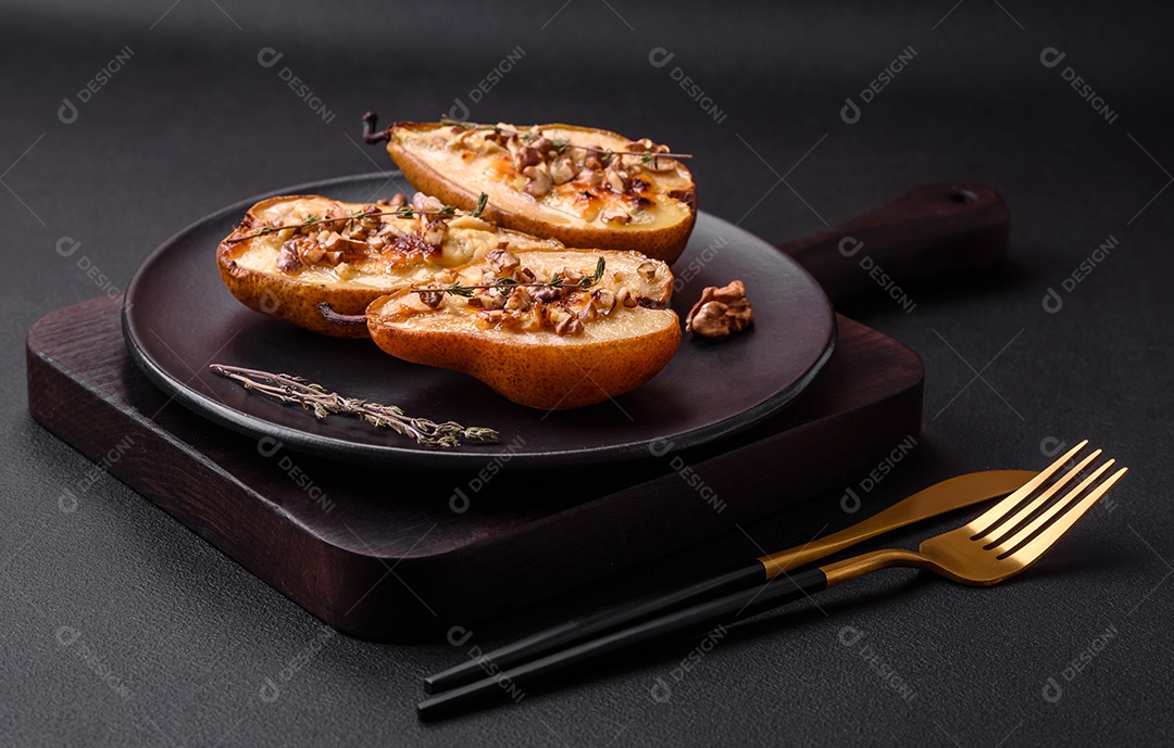 Deliciosa pêra assada com queijo dorblu, nozes e mel sobre um fundo de concreto texturizado. Prato vegetariano