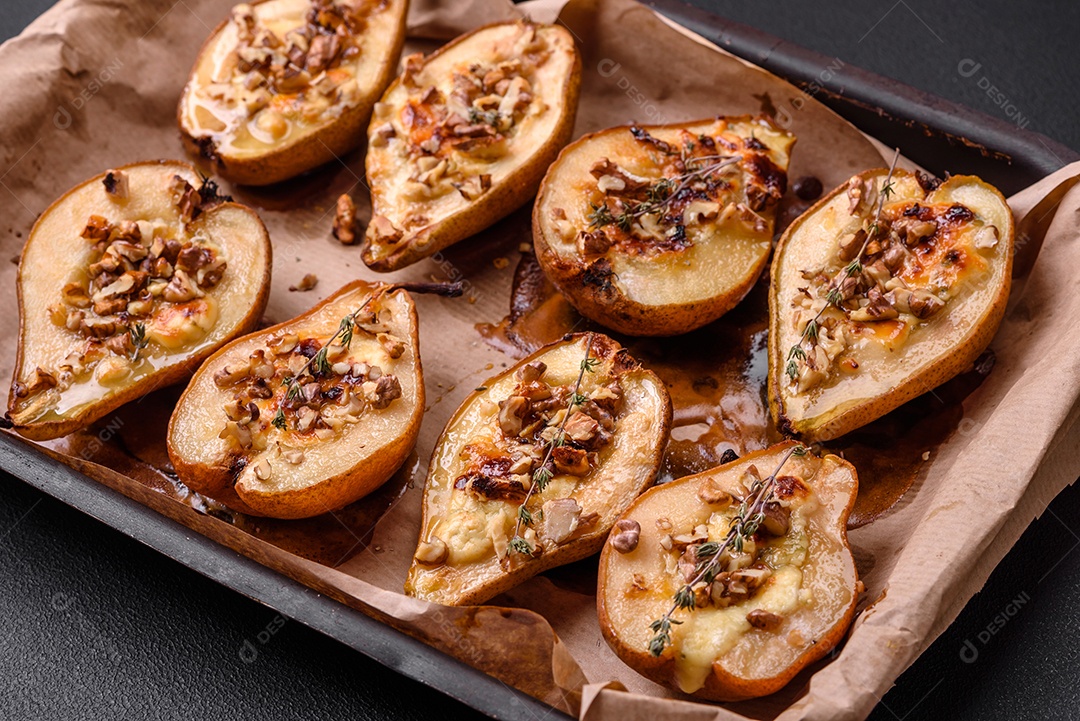 Deliciosa pêra assada com queijo dorblu, nozes e mel sobre um fundo de concreto texturizado. Prato vegetariano