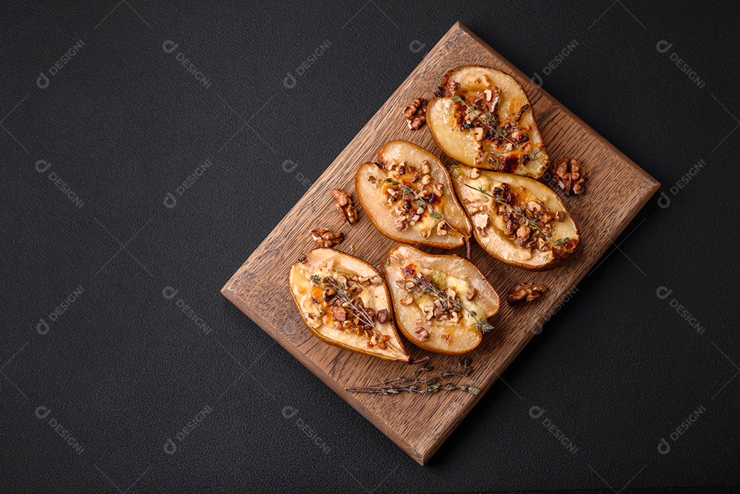 Deliciosa pêra assada com queijo dorblu, nozes e mel sobre um fundo de concreto texturizado. Prato vegetariano