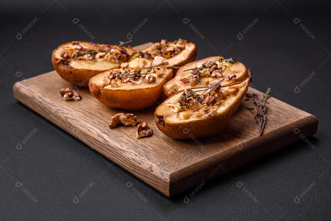 Deliciosa pêra assada com queijo dorblu, nozes e mel sobre um fundo de concreto texturizado. Prato vegetariano