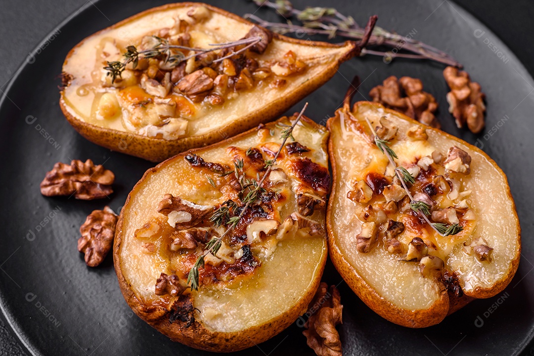 Deliciosa pêra assada com queijo dorblu, nozes e mel sobre um fundo de concreto texturizado. Prato vegetariano