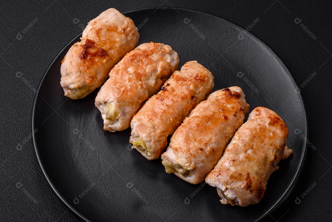 Delicioso rolo de porco ou frango assado com cogumelos, especiarias e ervas dentro sobre um fundo escuro de concreto