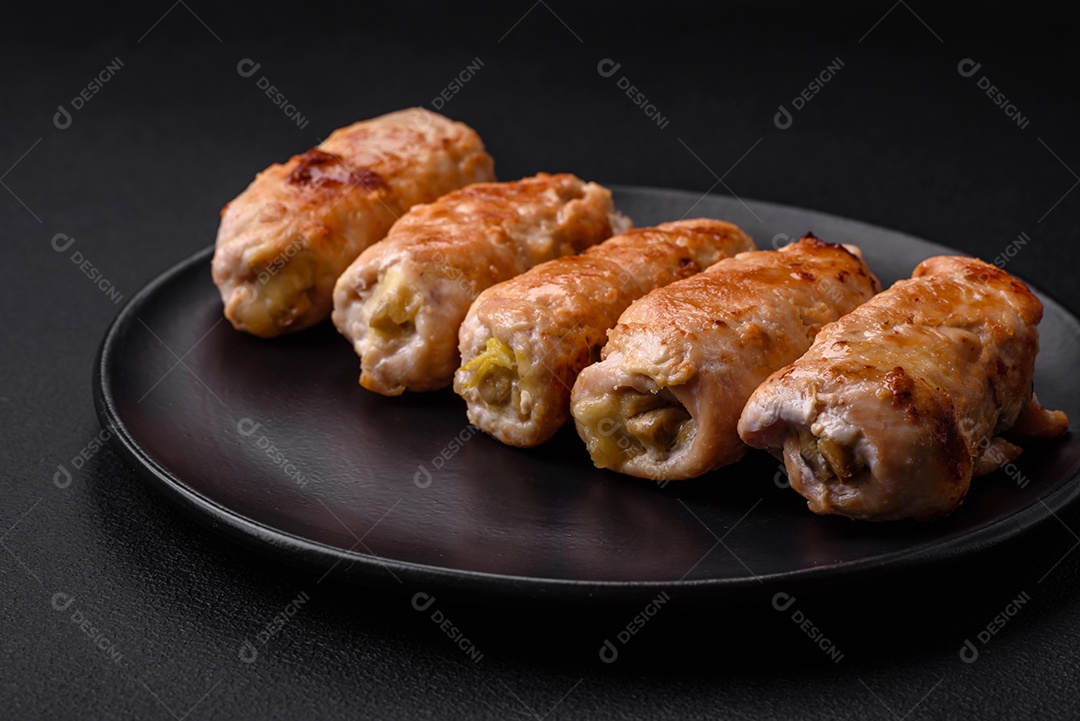 Delicioso rolo de porco ou frango assado com cogumelos, especiarias e ervas dentro sobre um fundo escuro de concreto