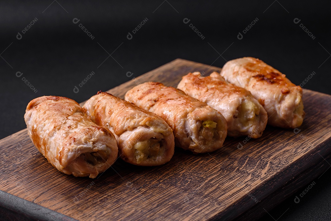 Delicioso rolo de porco ou frango assado com cogumelos, especiarias e ervas dentro sobre um fundo escuro de concreto