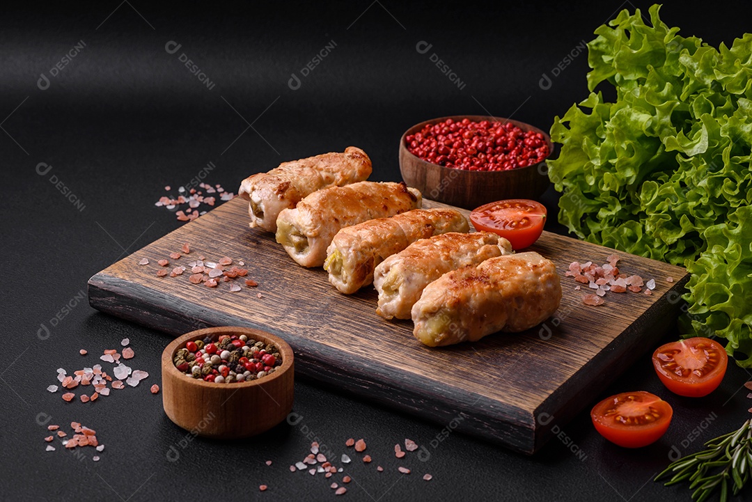 Delicioso rolo de porco ou frango assado com cogumelos, especiarias e ervas dentro sobre um fundo escuro de concreto